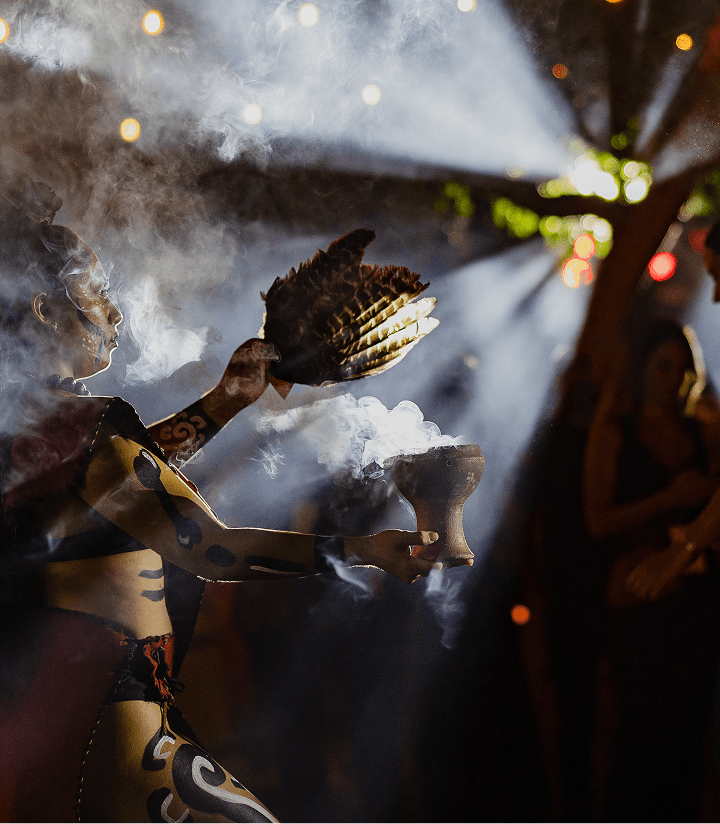 A ceremonial dancer in smoke and evening light at TFest